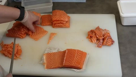 Under skilled hands fresh salmon is sliced into perfect portions. The chef caref Vidéo 284703184