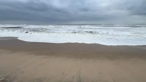Under a stormy sky the seawater pulls out leaving a fantastic pattern on the Stock Footage 325832312