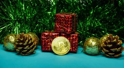 Under the tree, among the gift boxes, lies a gold bitcoin coin. Cryptocurrency Stock Photos