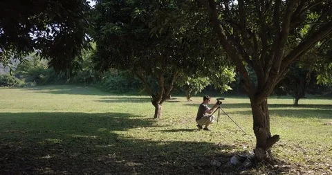 Under trees have a man is taking video, Chiang Mai Thailand Stock Footage 100746223