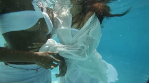 Under water shot of two young women, dressed in white dancing around Stock Footage 12909590