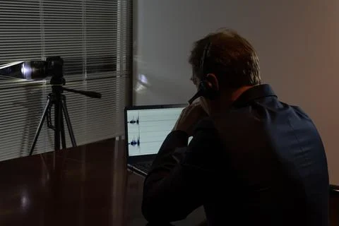 An undercover agent works at night: camera, headphones, audio recording on .. 写真素材