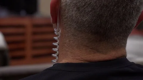 An undercover security guy wearing an earpiece Vídeos de archivo 261191802