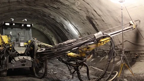 Underground drilling machine with massive hydraulic arms and tangled cables stan Stock Footage 309659923