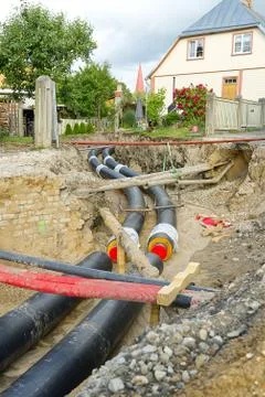 Underground heating system pipes replacement on the city street among the houses Stockfoto's