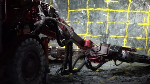 Underground Jumbo Operator drilling into rock and charging up the face of Stock Footage 121589071
