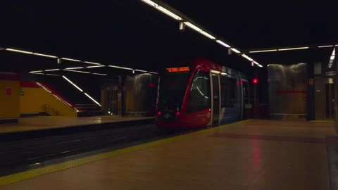 Underground light rail train departing from a modern subway station at night Stock Footage 329592862