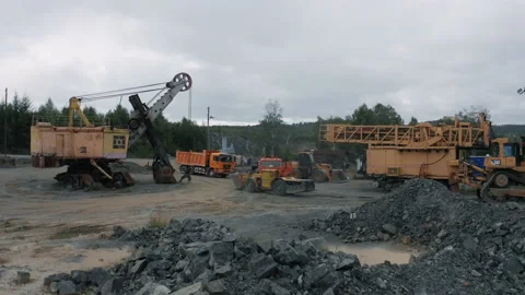 An underground loader rides past old mining equipment at a gold mining site. Stock Footage 220410128