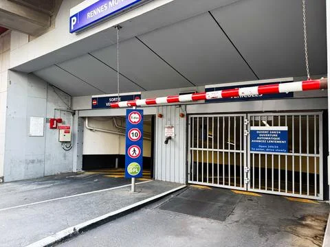 Underground parking garage exit with height restriction signs, barrier and .. Stock Photos