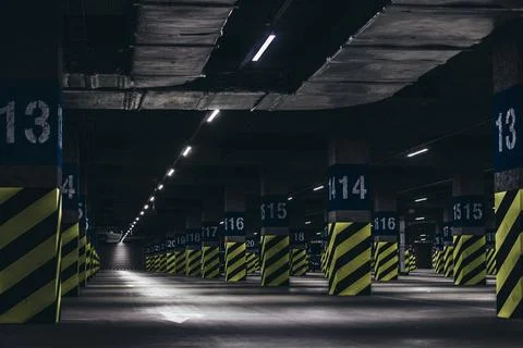Underground parking under the supermarket, poles painted with green black Stock Photos