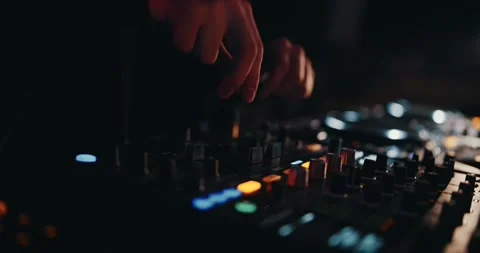 Underground Party DJ: Twisting knobs on his mixer and dancing to heat up 動画素材 263091864