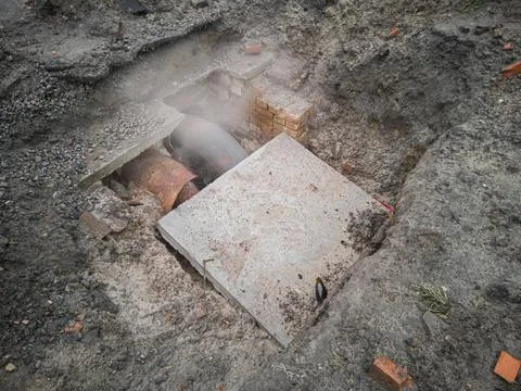 The underground pipe of the heating main from which steam comes is damaged Stock Photos