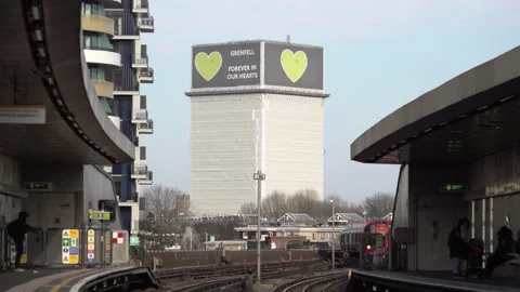 An Underground Train Pulls Into A Station In Front Of The Grenfell Tower Video stock 302827670