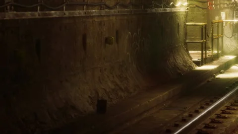 Underground train station with empty tracks and dim lighting in the evening Vídeos de archivo 344971136