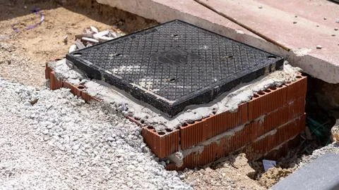 Underground Utility Access Cover Installed During Road Construction Фото