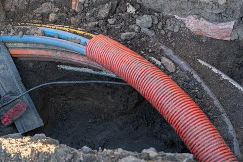 Underground Utility Cables and Conduit in Excavated Trench Stock Photos