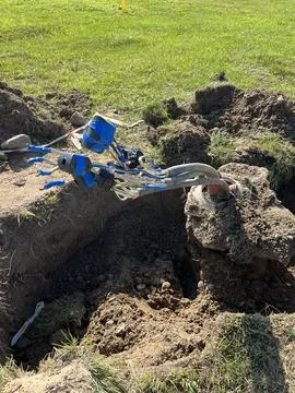 Underground utility cables exposed during electrical trenching work Stock Photos