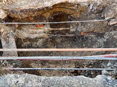 Underground utility scene. Damaged underground pipes amid muddy excavations.. Stockfoto's