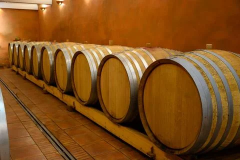 Underground wine cellars with barrels for aging of red dry wine in Chateaun.. Stock Photos