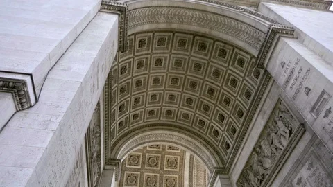 Underneath architecture of Arc de Triomphe tilting down to line of people Paris Stock Footage 93815765