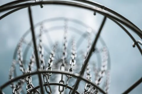 Underneath a disc golf goal looking up with selective focus on the chain basket. Stockfoto's