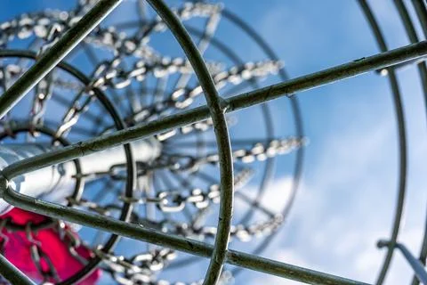 Underneath a disc golf goal looking up with selective focus on the chain basket. Stock-Fotos