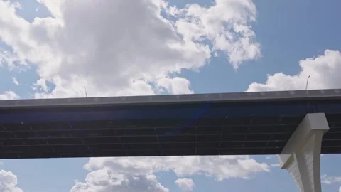 Underneath highway road way with car traffic summer day with white cloudscape Stock Footage 343436591