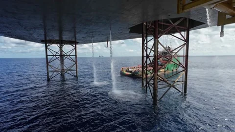 Underneath a jack up drilling rig and supply boat in the middle of the ocean Vídeo Stock 330557752