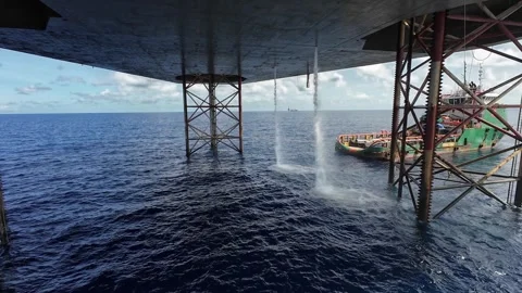 Underneath a jack up drilling rig and supply boat in the middle of the ocean Vídeo Stock 330557759