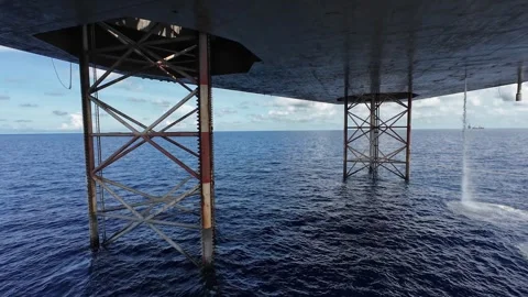 Underneath a jack up drilling rig and supply boat in the middle of the ocean 스톡 동영상 330557765