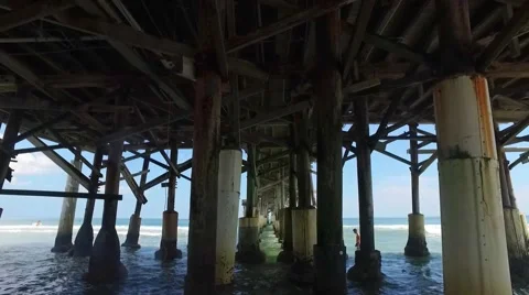 Underneath a pier on a beach during the day Stock Footage 68323046