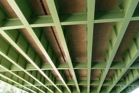 Underneath view of a green-painted bridge, showing the structure's metal beam Stock Photos