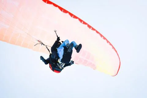 Underneath view instructor with tourist do paragliding in tandem while filmin Stock Photos