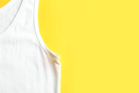 Undershirt with deodorant stain on yellow background, top view. Space for tex Stock Photos