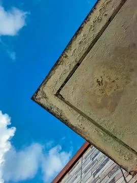 The underside of the concrete overhang shows significant peeling, bubbling,.. Stock Photos