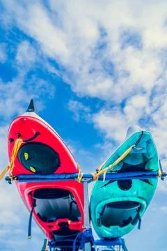 Underside of kayaks tied to rack on back of vehicle against blue sky with clouds Foto stock