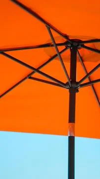 Underside of an orange beach umbrella showing the frame structure. Stock Photos