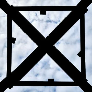 The underside of a structure with cross shape enclosed by a square with clouds Stock Photos