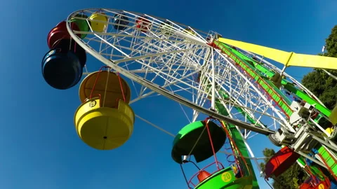 Underside view of bright colorful ferris wheel against sky in park. Time Lapse Stock Footage 247569327