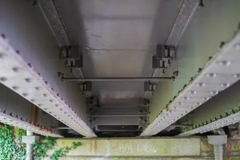 Underside view of riveted steel bridge girder structure and metal bracing e.. Stock-Fotos
