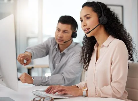 Understanding a few new processes. two call centre agents working together on a Stock Photos