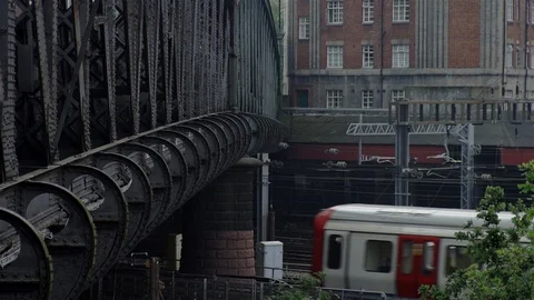 Undertround Tube train passing under iron bridge, London, UK Stock Footage 93209896