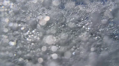 Underwater air bubbles and tiny particles drift through seawater with reflected Stock Footage 343707529