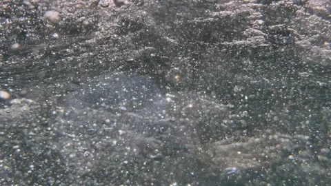 Underwater air bubbles move through seawater with reflected light visible across Видео 341111888