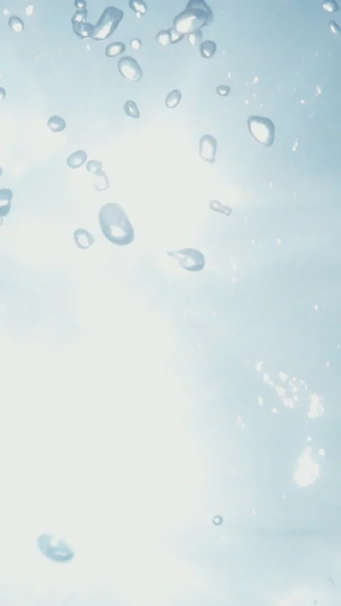 Underwater air bubbles rising from deep water up to the surface in tropical sea Stock Footage 284005187