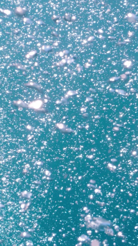 Underwater air bubbles rising from deep water up to the surface in tropical sea Stock Footage 284005895