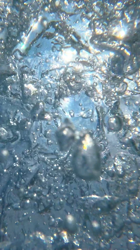 Underwater air bubbles rising toward sunlit surface in shallow water Stock Footage 342157168