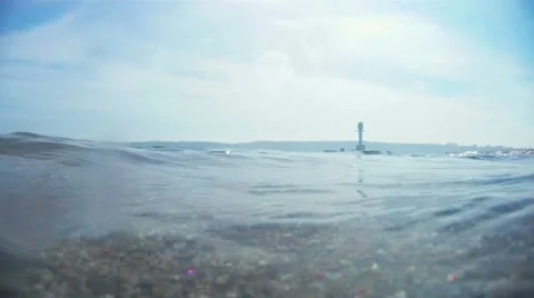 Underwater breaking waves with lighthouse on the horizon Video stock 11864520