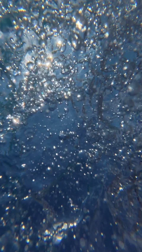 Underwater bubbles and splashes rising beneath swimming pool surface at dayti Stock Footage 342049076