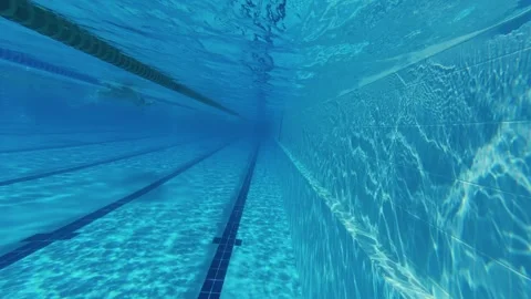 Underwater camera movement in swimming pool with swimmers in lanes Stock-Footage 343936643